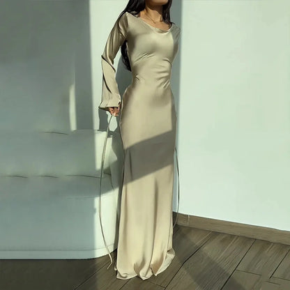 A woman gracefully modeling the Sophia | Women's Elegant Maxi Dress | Flowy Evening Gown, showcasing its sophisticated and flowing design, perfect for formal events or special occasions. The dress features long sleeves and a fitted silhouette that exudes elegance and charm.