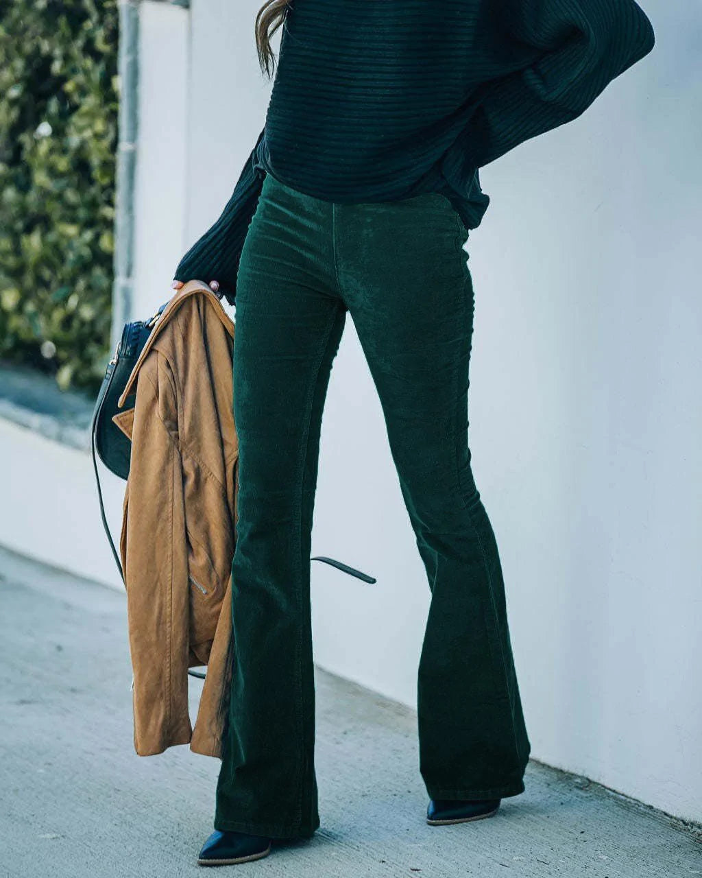 Model wearing the Isabelle | High-Waisted Flare Pants, featuring a flattering high-waist and chic flare cut. These pants offer a sleek, leg-lengthening silhouette, perfect for casual or dressy outfits, paired with a cozy knit sweater and neutral accessories.