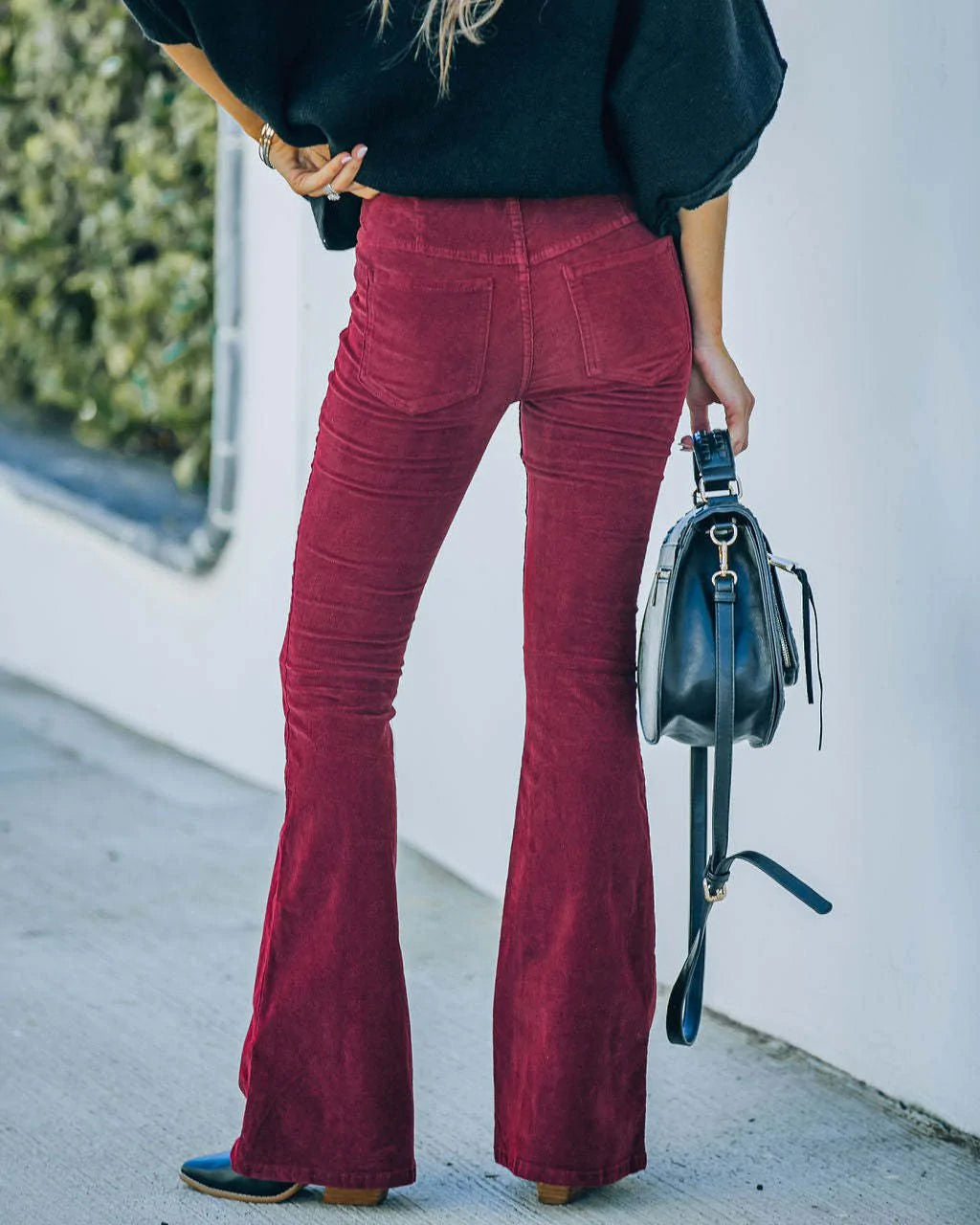 Model wearing the Isabelle | High-Waisted Flare Pants, featuring a flattering high-waist and chic flare cut. These pants offer a sleek, leg-lengthening silhouette, perfect for casual or dressy outfits, paired with a cozy knit sweater and neutral accessories.