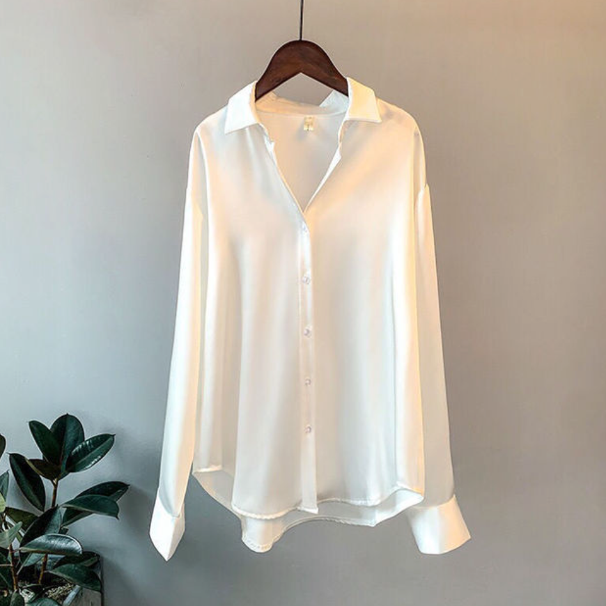 Elegant women's satin button-up shirt featuring a timeless design, styled for both casual and formal occasions, paired with a sophisticated clutch for a chic look.