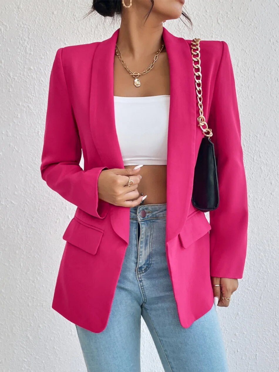 A woman wearing a stylish tailored blazer over a crop top and high-waisted jeans, creating a chic and modern look. The blazer features a structured fit with pockets, adding sophistication to the casual outfit. Perfect for elevating any ensemble with a touch of elegance.