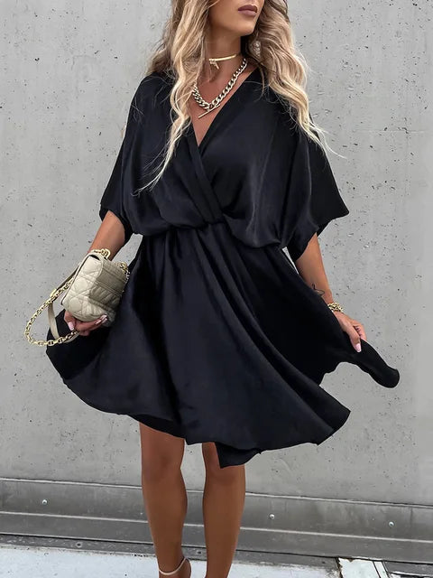 A stylish woman wearing the Lila Women's Flowy Wrap Dress with a flattering wrap design and flowing fabric, accessorized with jewelry and a chic handbag, perfect for an elegant evening look.