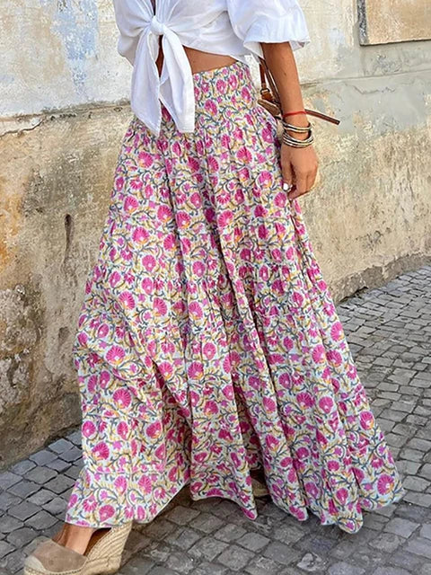 Stylish woman wearing a flowy maxi skirt with a bohemian pattern, paired with a tied blouse and accessories, showcasing a chic and effortless outfit perfect for casual and festive occasions.