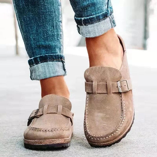 Women's stylish loafers with a comfortable design, featuring a slip-on style and elegant buckle detail, paired with rolled-up denim jeans for a casual look.