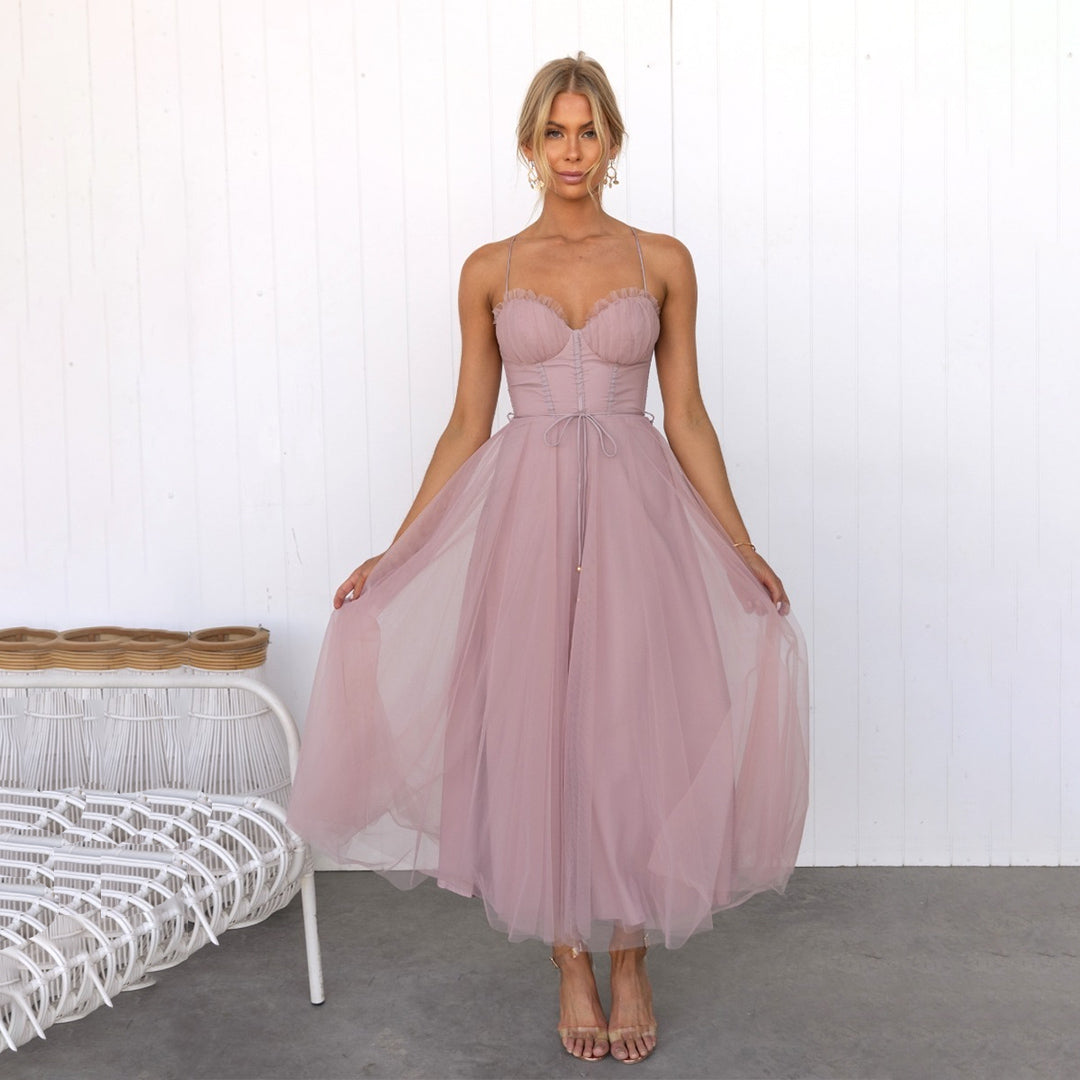 A woman wearing a stylish midi dress with a tulle skirt, fitted bodice, and delicate straps, posing gracefully in an elegant setting. The dress flows beautifully, creating a romantic and sophisticated look, perfect for special occasions.