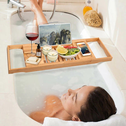 Bath tray with a multi-functional design holding a glass of wine, tablet, and smartphone on a bathtub, showcasing its compartments and adjustable layout for added convenience and relaxation.