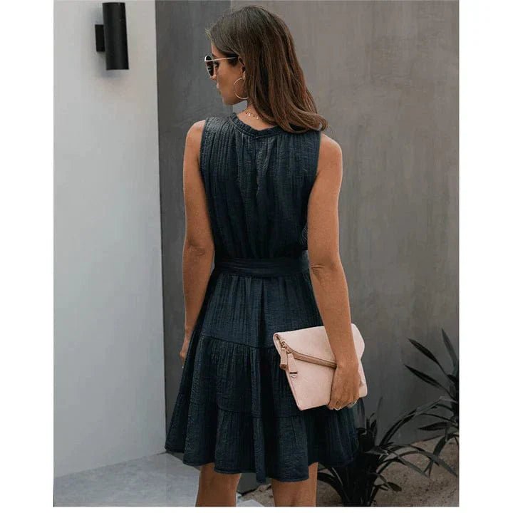 Back view of a woman wearing the Leah Women's Sleeveless Dress, a short dress with a flowy, tiered skirt, perfect for casual or semi-formal occasions.