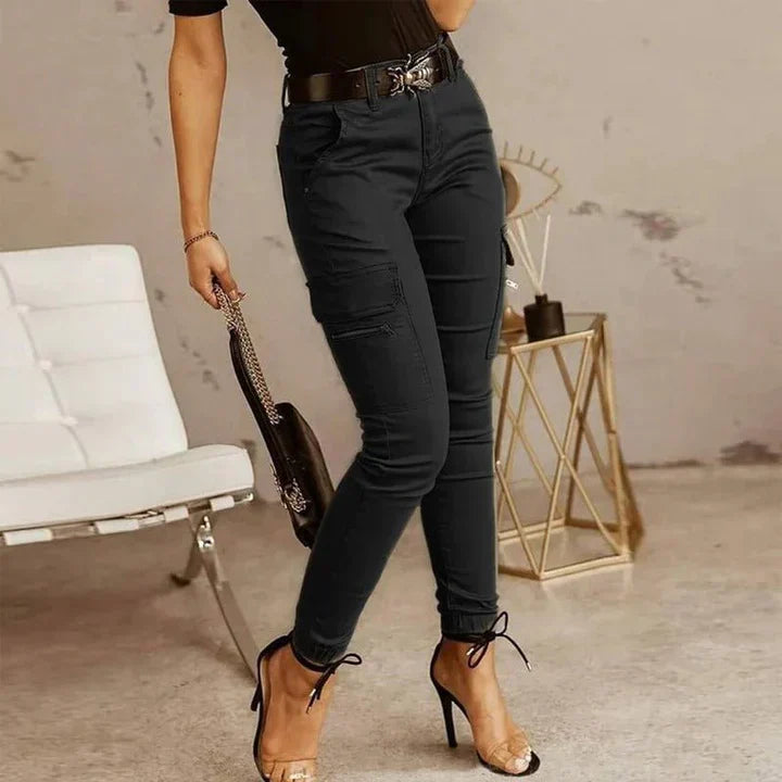 A woman wearing slim-fit high-waist cargo pants paired with heels, featuring functional side pockets and a belt for a chic, polished look. The pants have a fitted silhouette, ideal for both casual outings and dressier occasions.