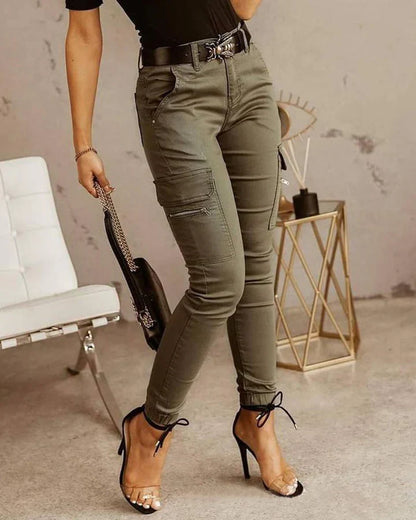 A woman wearing slim-fit high-waist cargo pants paired with heels, featuring functional side pockets and a belt for a chic, polished look. The pants have a fitted silhouette, ideal for both casual outings and dressier occasions.