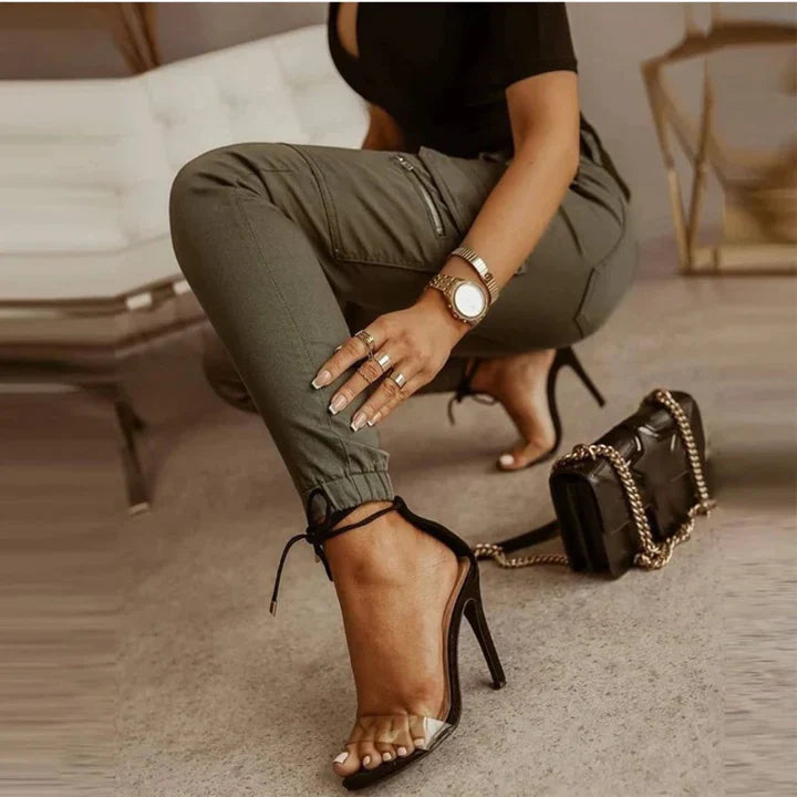 A woman wearing slim-fit high-waist cargo pants paired with heels, featuring functional side pockets and a belt for a chic, polished look. The pants have a fitted silhouette, ideal for both casual outings and dressier occasions.