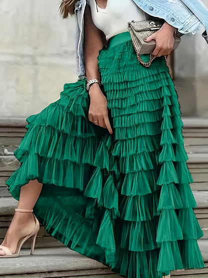 Woman wearing the Sophie Women's Layered Tulle Skirt, a ruffled skirt with multiple soft layers, creating a flowing and voluminous look, styled with a sleeveless top and accessories, standing on steps outdoors.