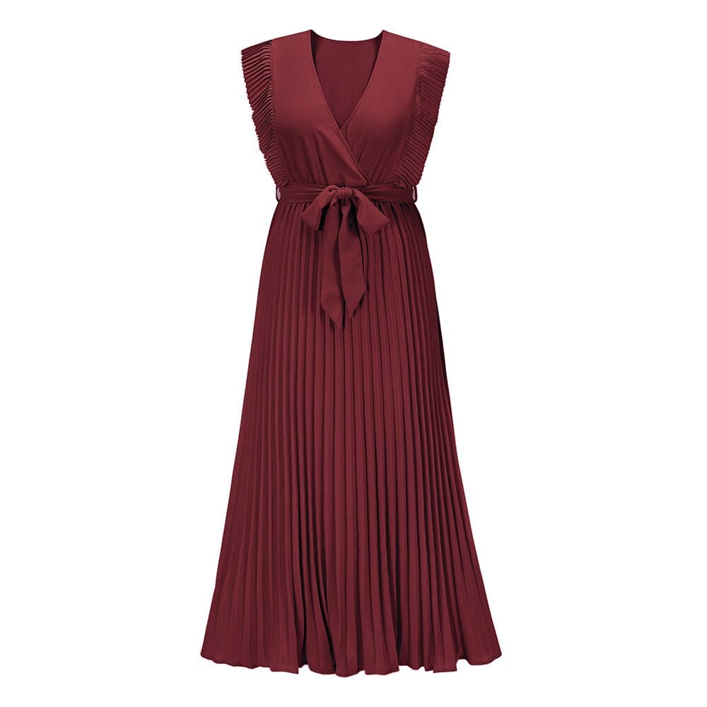 Woman wearing the Amara | Ruffled Sleeveless Pleated Maxi Dress, featuring elegant ruffles and a flowing pleated design, styled with heels and a handbag in an urban outdoor setting.