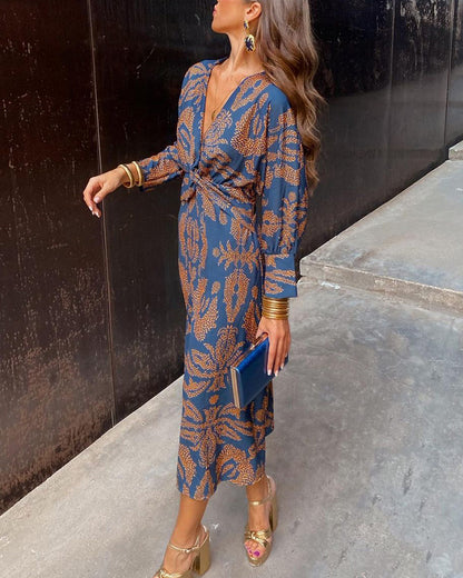 A close-up of a woman wearing the Nina Women's Elegant Wrap Dress, featuring a bold pattern and flattering wrap design with a deep V-neckline. The dress showcases intricate patterns and a knot detail at the waist, creating a sophisticated and stylish look suitable for special occasions.