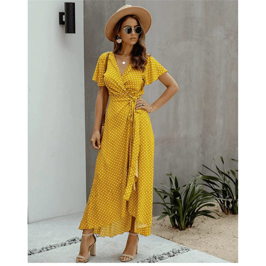 Image of a woman wearing the Mila Women's Flowy Wrap Dress, a stylish midi dress with a wrap design, flutter sleeves, and a flowing skirt, perfect for casual and semi-formal occasions. The dress exudes effortless elegance and complements any outdoor or relaxed setting.