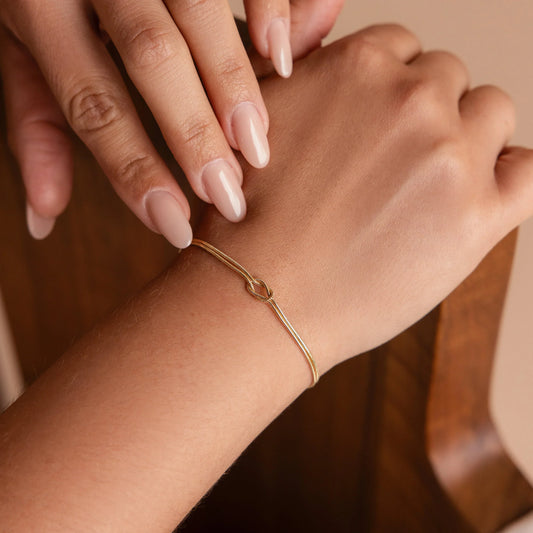 Close-up of the Nora Women's Knot Bracelet featuring a minimalist and elegant knot design, displayed on a soft surface for a refined and stylish look.