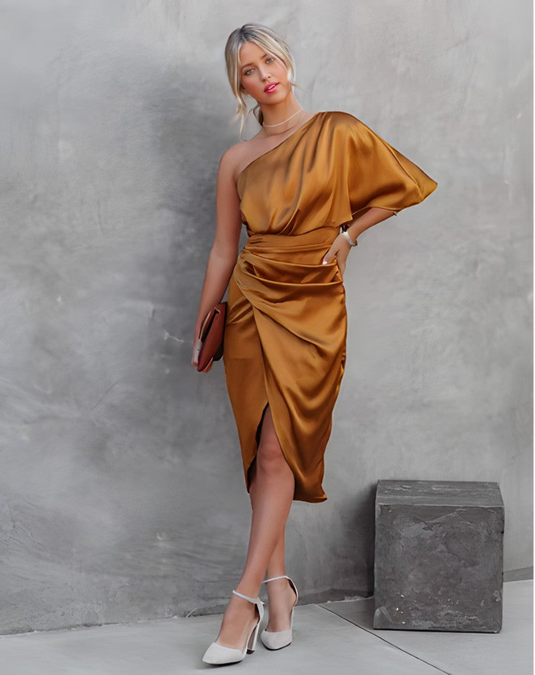 A woman standing in front of a decorated Christmas tree, wearing a stylish one-shoulder party dress with a ruched wrap design. The dress features an elegant silhouette, perfect for festive celebrations and special events. She is smiling and ready for the occasion.