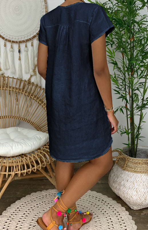 Woman wearing the Lily | Women's Casual Tunic Dress | Relaxed Fit Dress, accessorized with a long beaded necklace and casual shoes, standing next to a cactus and woven decor.