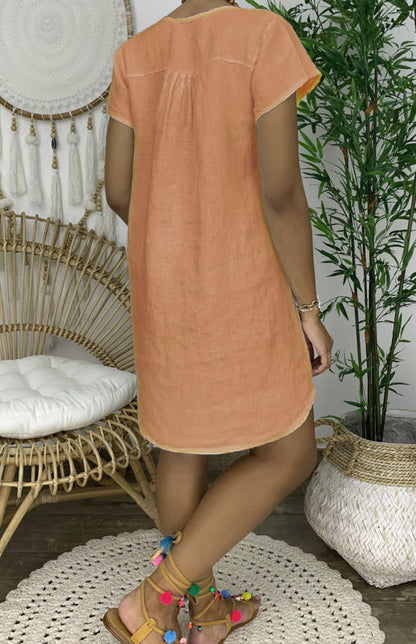 Woman wearing the Lily | Women's Casual Tunic Dress | Relaxed Fit Dress, accessorized with a long beaded necklace and casual shoes, standing next to a cactus and woven decor.