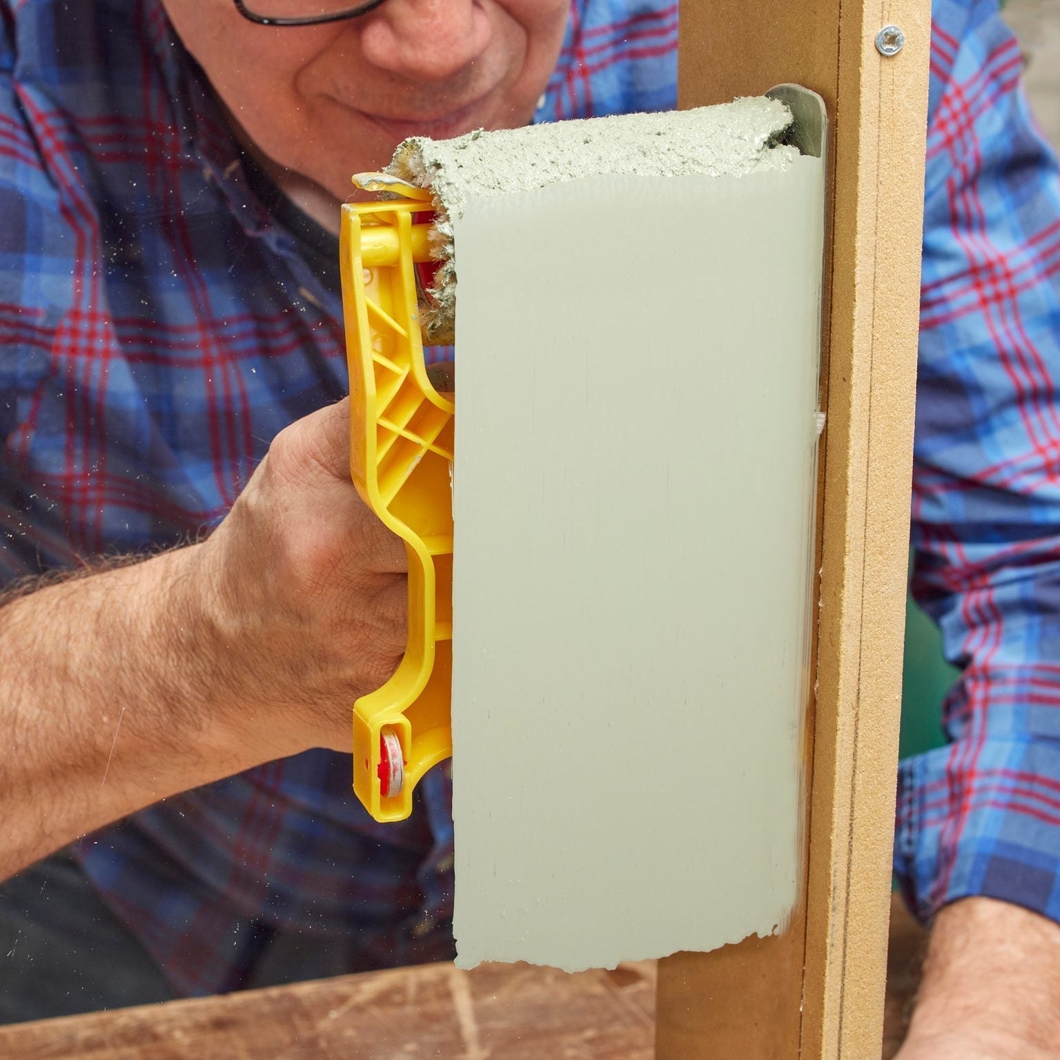 Hand using a precision paint roller with an edge guard, showcasing its ability to create clean and sharp lines for a flawless painting finish.