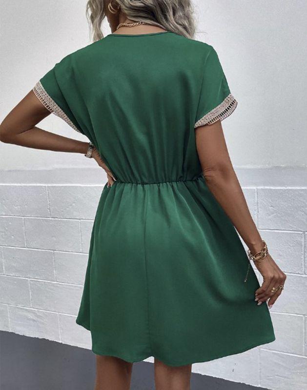 Woman wearing the Leah | Boho V-Neck Drawstring Dress with a relaxed fit and delicate detailing around the neckline. The dress is styled with a cinched waist, achieved through a drawstring, and paired with layered necklaces and a stylish handbag for a chic bohemian look.