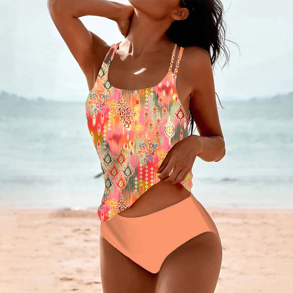 A woman wearing the Maya Women's Boho One-Piece Swimsuit with a vibrant mandala print and a stylish cut-out design at the waist, standing on a beach. This swimsuit features a boho-inspired look, perfect for adding unique flair to beach or poolside outfits.