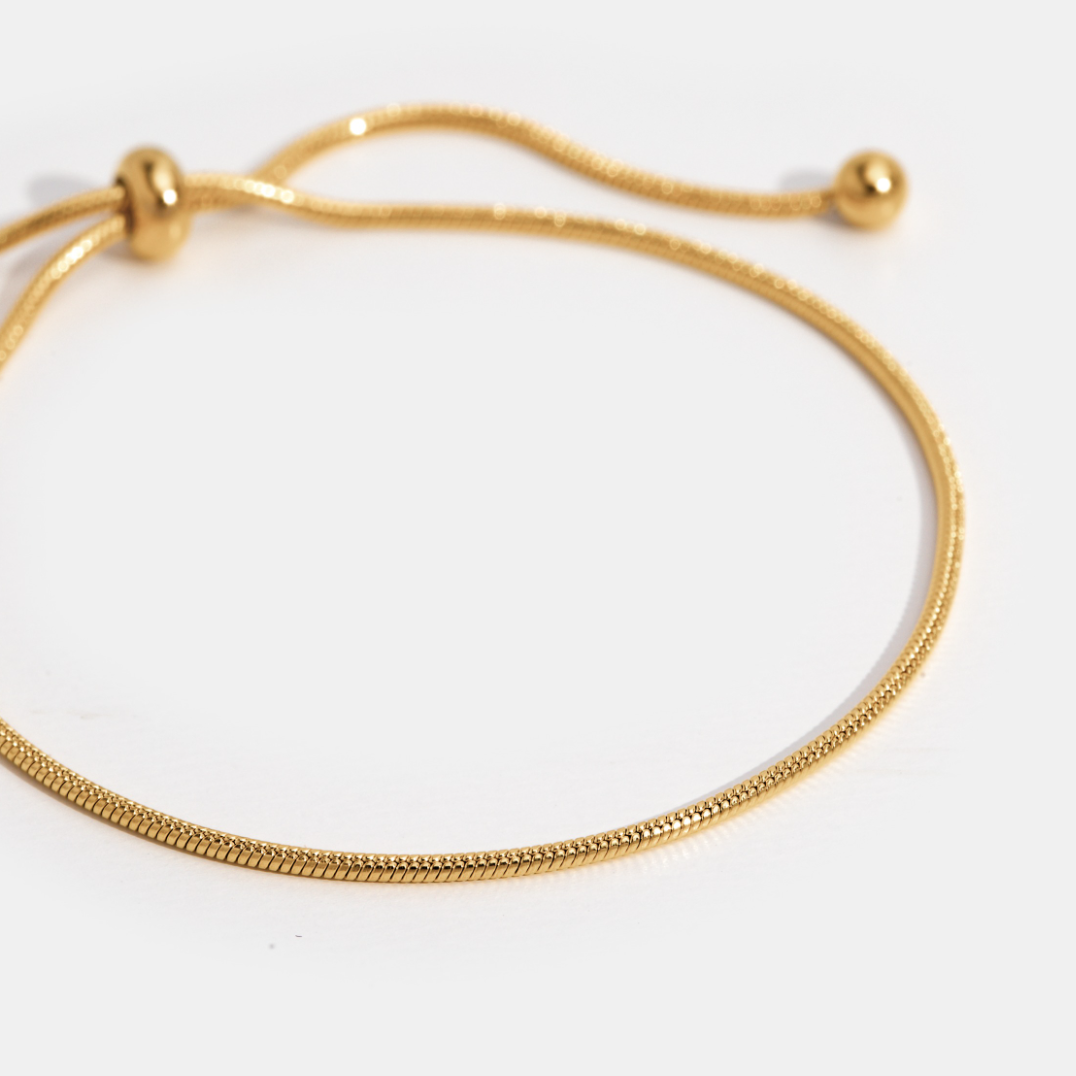 Smiling woman showcasing the Sophia Women's Adjustable Bracelet on her wrist, featuring a sleek and minimalist design. A stylish and versatile accessory perfect for any occasion.