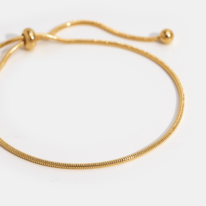 Smiling woman showcasing the Sophia Women's Adjustable Bracelet on her wrist, featuring a sleek and minimalist design. A stylish and versatile accessory perfect for any occasion.
