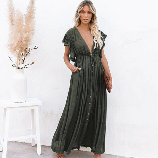 Woman wearing the Sienna Women's Button-Down Maxi Dress, a long, flowing dress with a relaxed fit and button-down front, posing elegantly with her hand in a pocket, holding a clutch, against a minimalist background.