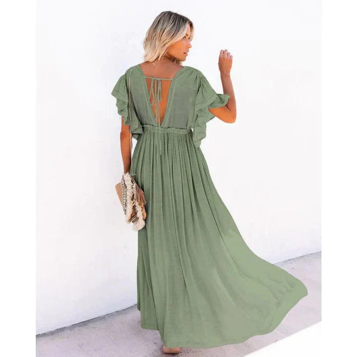 Woman wearing the Sage Women's Button-Down Maxi Dress, a long, flowy dress with a relaxed fit, button-down front, and functional side pockets, styled with a casual boho-chic look, holding a woven bag and posing outdoors against a simple background.