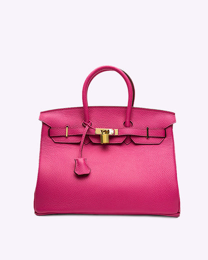 Image showing a woman holding an elegant handbag with a sleek design, featuring gold hardware and a structured shape, paired with casual attire for a stylish, sophisticated look.