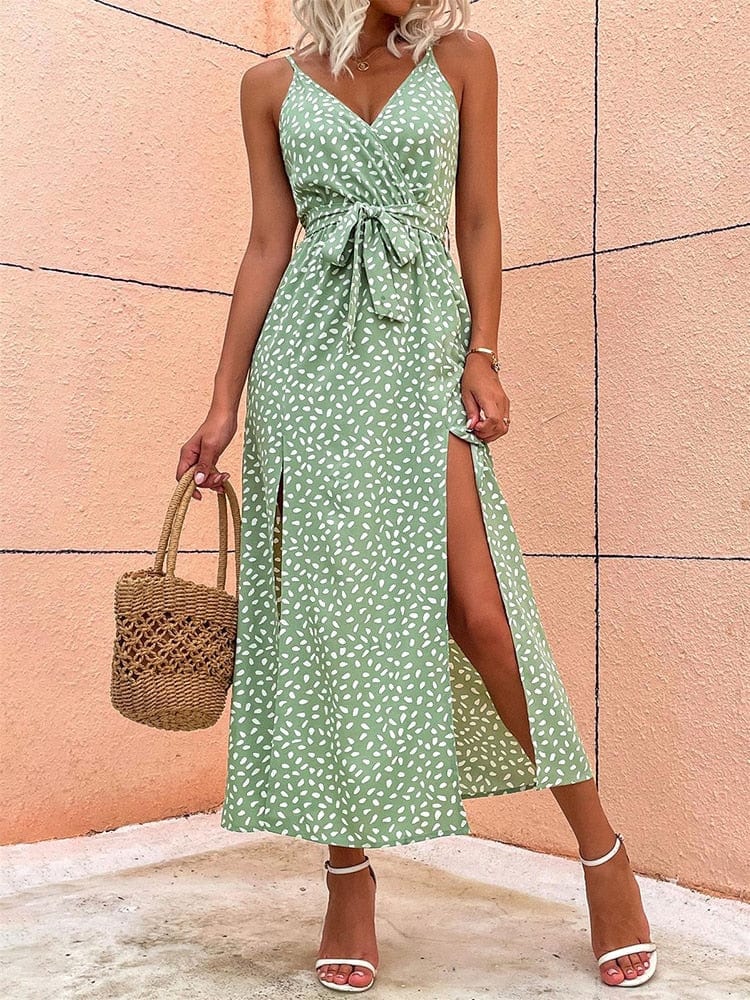 A woman wearing the Elara Women's Summer Wrap Dress with a sleeveless, wrap design, tied waist, and elegant side slits. This stylish and lightweight dress is perfect for warm weather, accessorized with a woven handbag and strappy heels for a chic summer look.