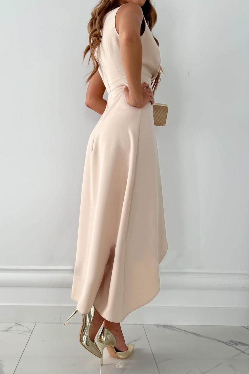 Woman wearing the Elena | Women's Asymmetric Wrap Dress | Elegant Dress, showcasing a sophisticated wrap design with a high-low hemline, styled for a formal or upscale event. She holds a small clutch, completing an elegant and refined look.