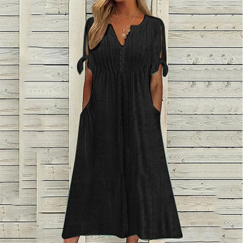 A stylish midi dress featuring intricate eyelet detailing, open sleeves with tie accents, a flattering V-neckline, and a relaxed fit, perfect for casual or semi-formal occasions.