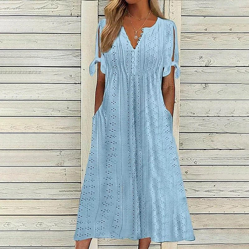 A stylish midi dress featuring intricate eyelet detailing, open sleeves with tie accents, a flattering V-neckline, and a relaxed fit, perfect for casual or semi-formal occasions.