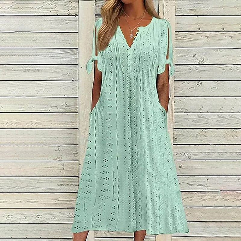 A stylish midi dress featuring intricate eyelet detailing, open sleeves with tie accents, a flattering V-neckline, and a relaxed fit, perfect for casual or semi-formal occasions.