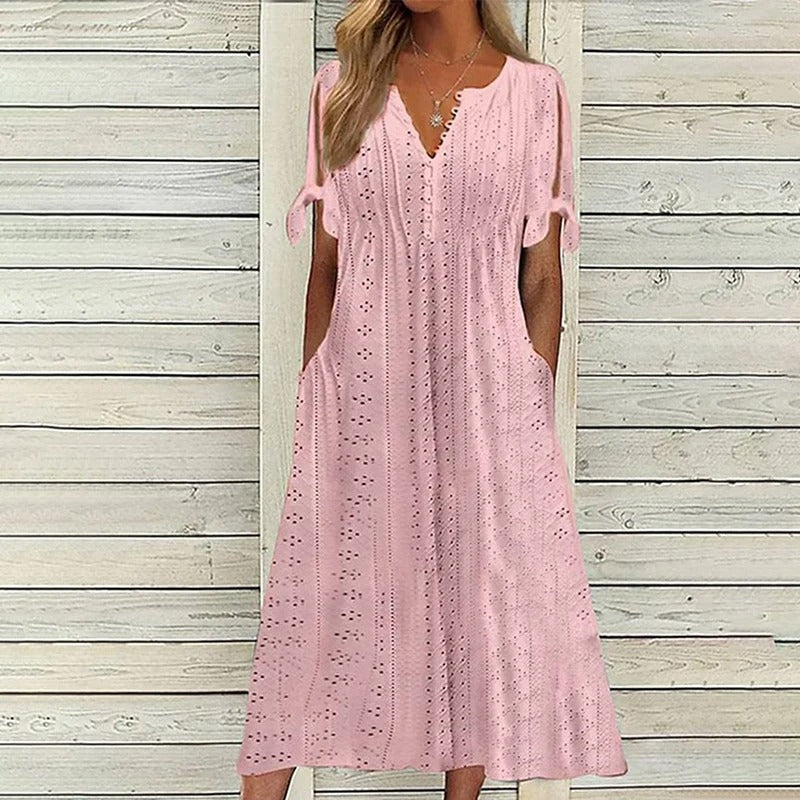 A stylish midi dress featuring intricate eyelet detailing, open sleeves with tie accents, a flattering V-neckline, and a relaxed fit, perfect for casual or semi-formal occasions.