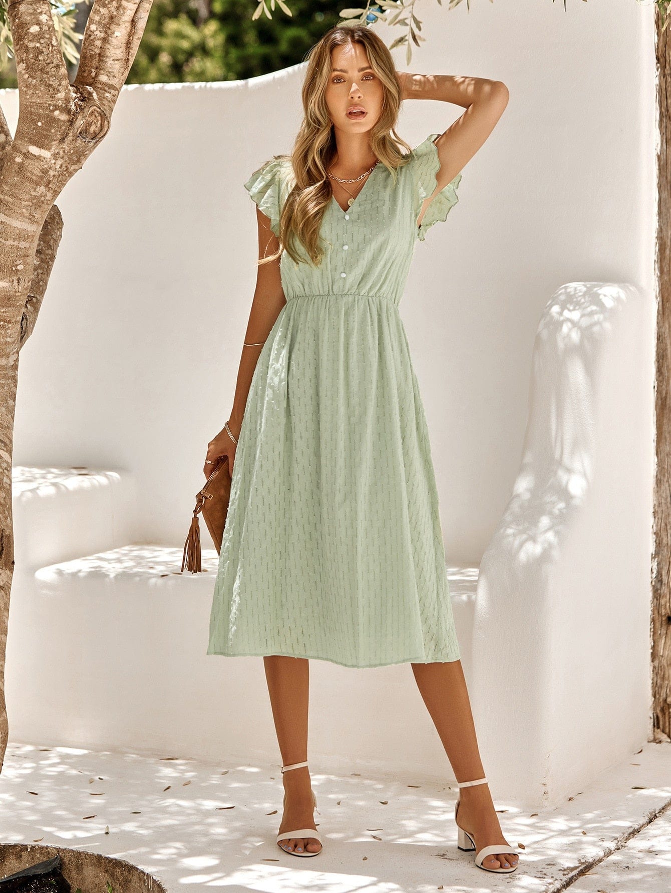Model wearing the Grace Women's Midi Dress, featuring a flattering cinched waist, flutter sleeves, and a classic midi-length design, styled with sandals and a clutch for an elegant look.