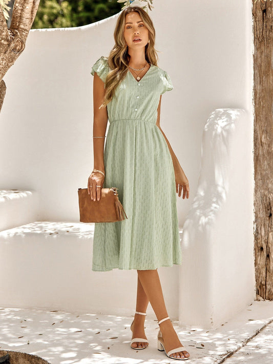 Model wearing the Grace Women's Midi Dress, featuring a flattering cinched waist, flutter sleeves, and a classic midi-length design, styled with sandals and a clutch for an elegant look.