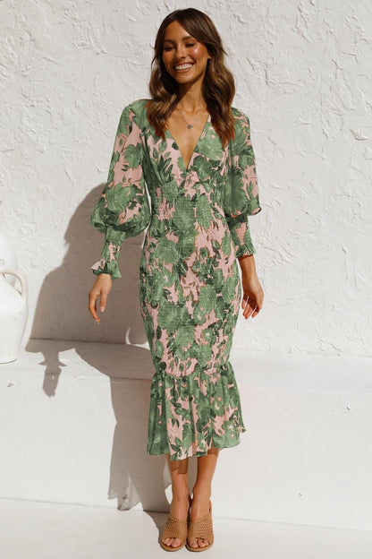 Model wearing Emilia, a women's floral midi dress with elegant ruffled sleeves, a fitted waist, and a flowing hemline, perfect for a chic and stylish look.